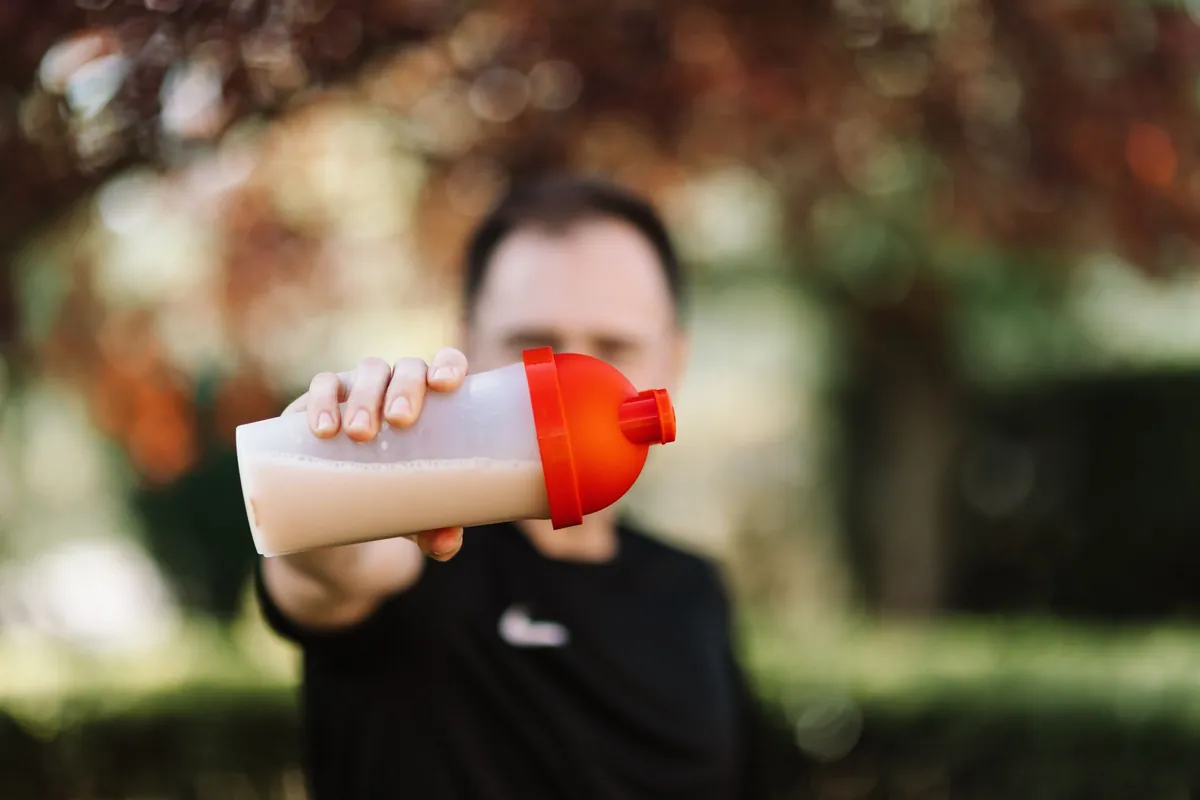 Un vaso mezclador con un batido de proteína recién agitado, en primer plano