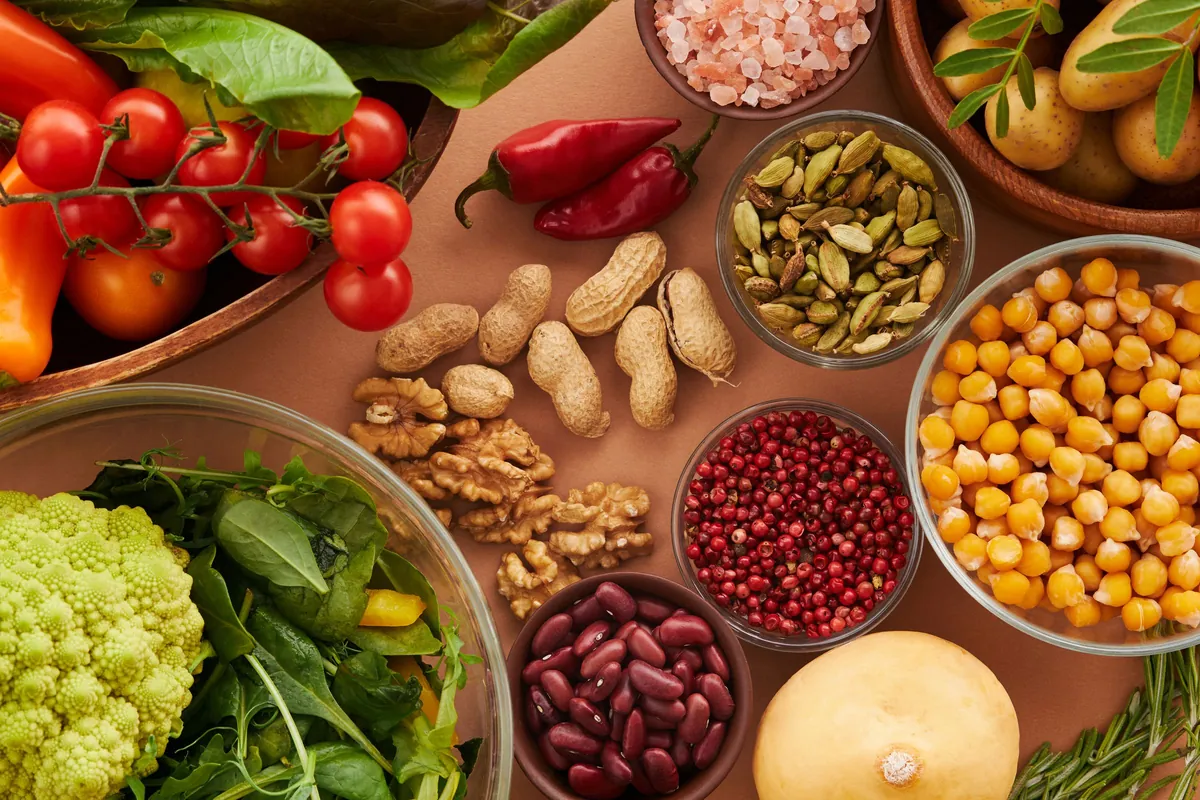 Garbanzos, alubias, nueces, cacahuetes y verdura de hoja verde sobre una mesa