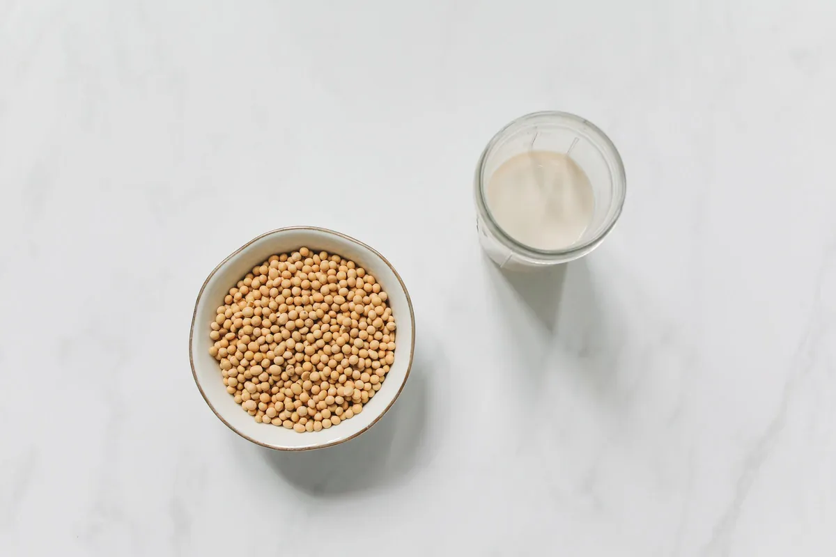 Soja en grano y un vaso de bebida de soja